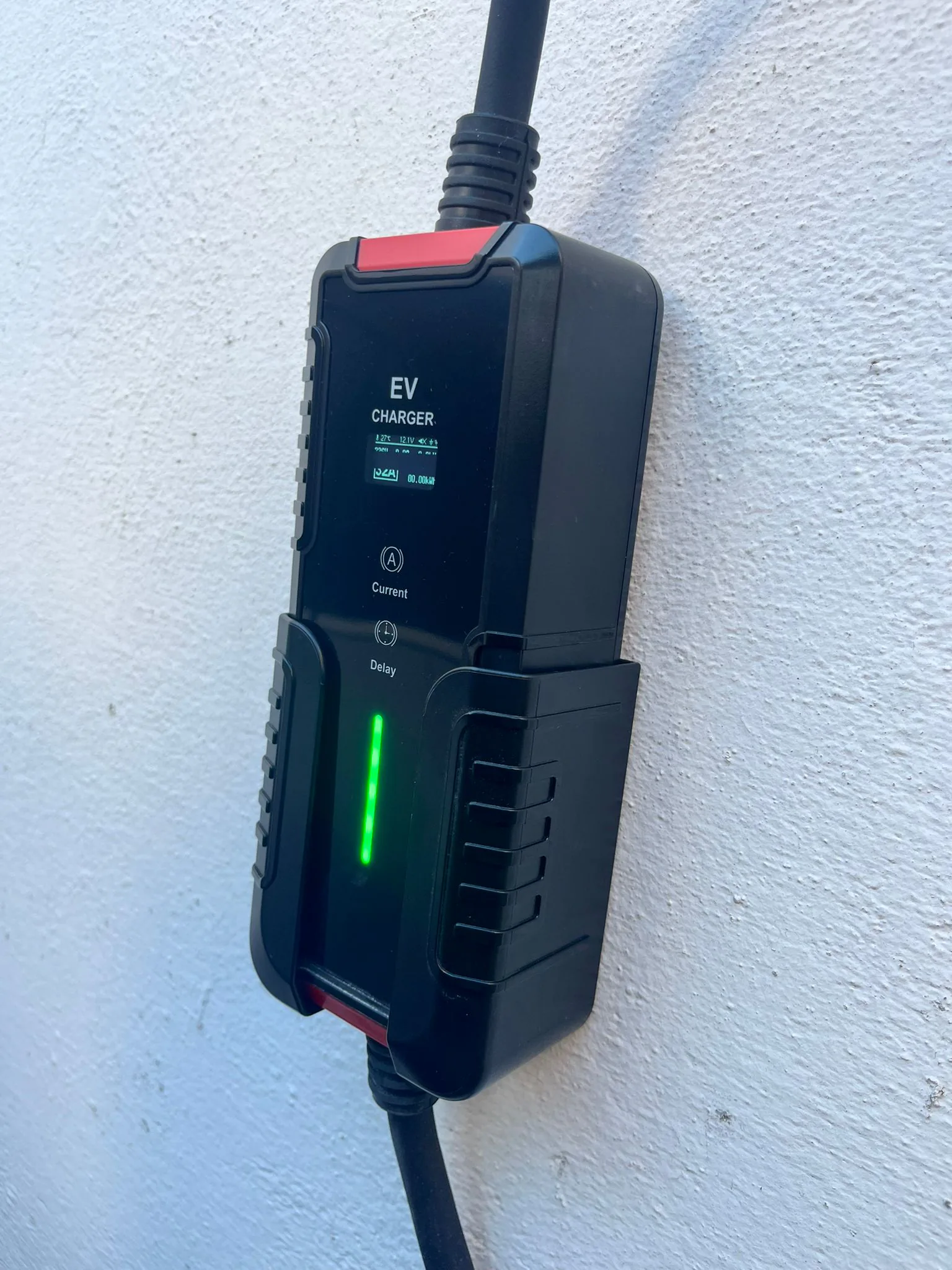 Cargador portátil Alectra instalado y listo para uso sobre pared blanca.